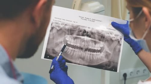 Dentists Reviewing Dental X-Ray in Clinic