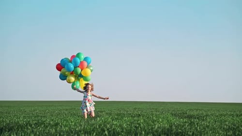 Happy Girl Runs with Balloons in Green Field
