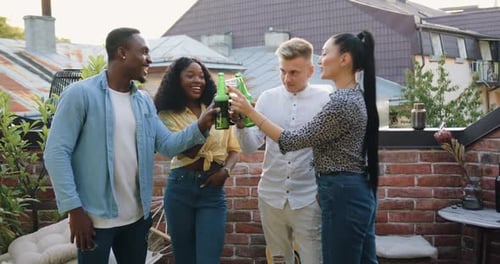 Friends which Have Terrace Party and Clinking Bottled Beer and Glasses with Wine