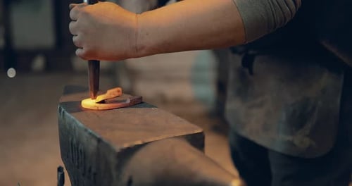 Blacksmith Shaping Hot Metal into Horseshoe on Anvil
