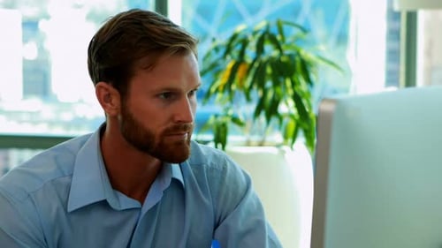 Man Works On Computer in Office Environment