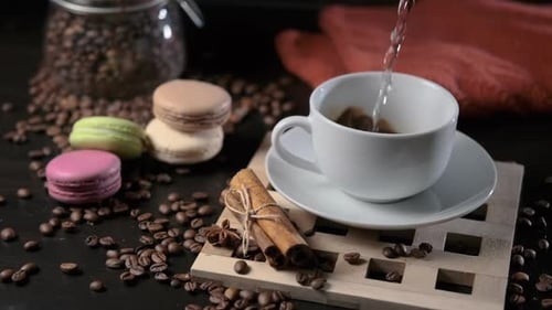 Pouring Water into Coffee Cup with Macaroons
