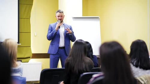 Speaker on the podium. People at the conference hall. Rear view
