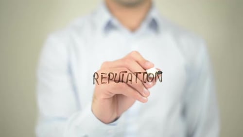 Man Writes the Word Reputation on Clear Surface
