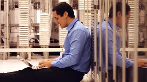 Techniker arbeitet am Laptop im Flur
