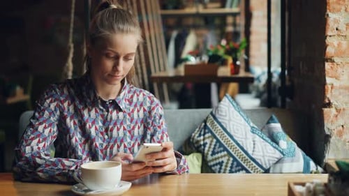 Attractive Young Woman Using Modern Smartphone in Coffee Shop Touching Screen
