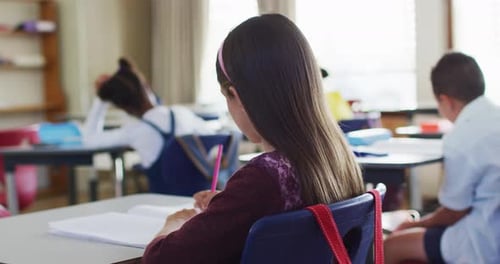 Young Girl Writing in Classroom Setting