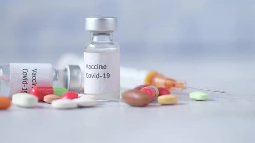 Close Up of Coronavirus Vaccine and Syringe on Black Background