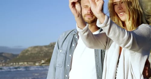 Couple taking selfie on mobile phone at beach