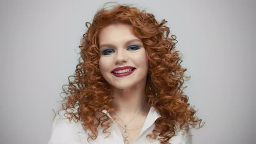 Sexy Woman Flirting with Camera. Closeup Smiling Redhead Girl in Studio