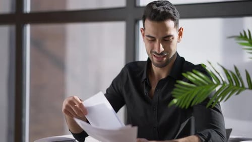 Angry Stressed Anxious Man Throwing Away Documents Sitting on Armchair at Window in Home Office
