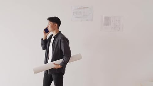Young Adult on Phone with Construction Blueprint