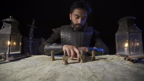 Man Moves Figures on Map By Candlelight