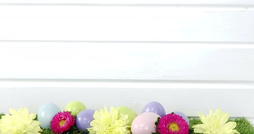Pastel Easter Eggs and Flowers on Green Grass