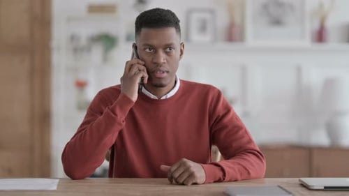 African Man Talking on Phone in Office
