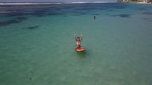 Woman Relaxing in the Sea on a Surfboard