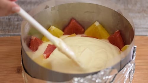 Pouring Cream into Cake with Fruit Pieces