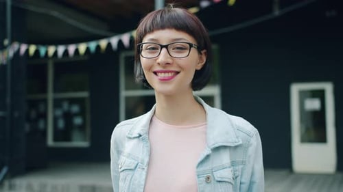 Smiling Woman with Glasses Poses Outdoors