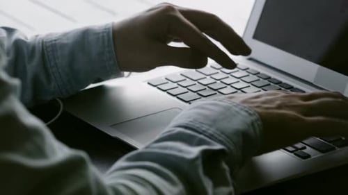 Mann arbeitet online mit Laptop