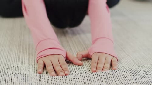 Close-up woman lying on the floor doing yoga sport exercises indoor at home.
