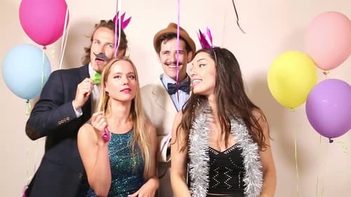 Group of happy friends in party photo booth