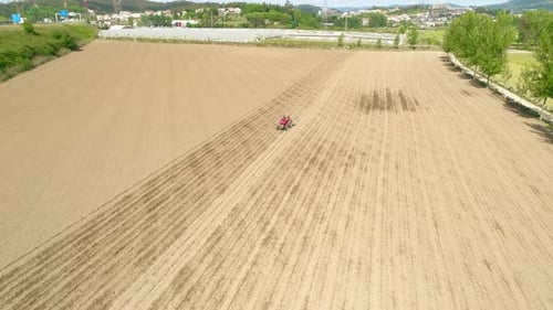 Tractor Tilling Soil in Rural Agricultural Field