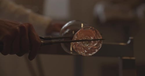 Professional glassblower working with glass at the workshop