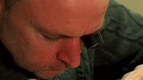 Man Performing Meticulous Technical Work With Magnifying Glass