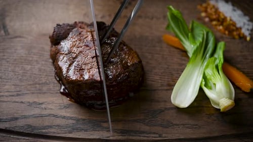 Cutting a Delicious Steak on Wood Cutting Board