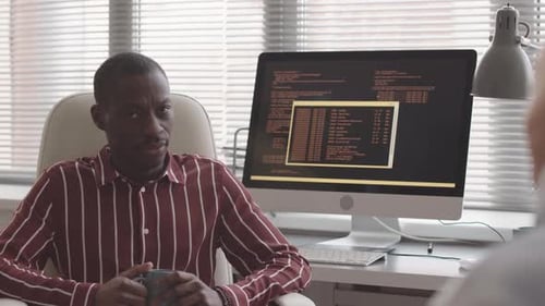African American Programmer Talking to Colleague in Office