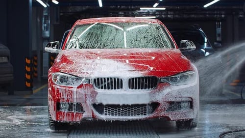 Car Wash: Red Car Undergoing Cleaning Process