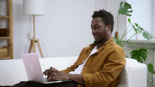 Young Adult Working on Laptop at Home