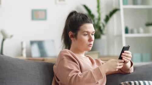 Woman Relaxing on Couch using Smartphone