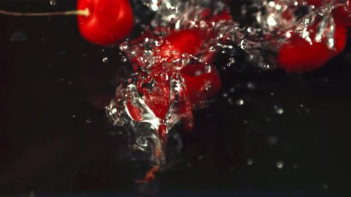 Super Slow Motion Cherry Falls Into the Water with Splashes and Air Bubbles