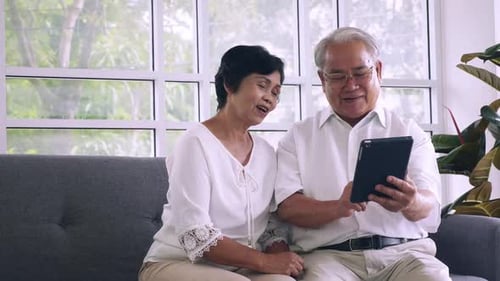 Senior Couple Using Tablet in Bright Living Room