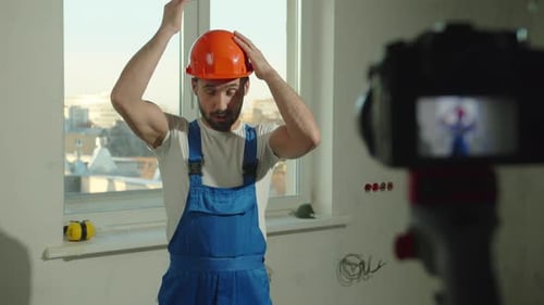 Slow Motion, Builder Puts on Helmet and Talks on Camera