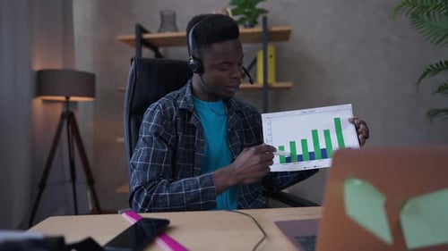 Young Adult Presenting Data Graph in Home Office