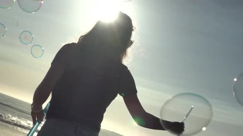 Woman Making Bubbles on a Sunny Beach