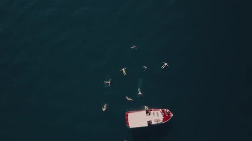 Aerial view of swimming people at sea by boat in the mountains in Montenegro