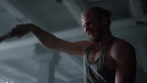 Strong Sportsman Battling Ropes in Gym