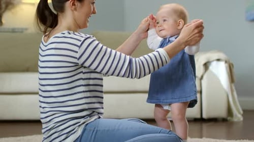Baby macht Tanzbewegungen mit Mutter