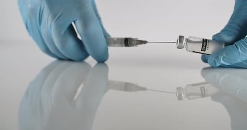 Medical Professional Extracting COVID-19 Vaccine into Syringe