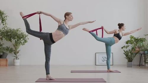 Two Women Practice Yoga Dancer Pose with Bands