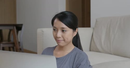 Woman Working on Computer at Home on Couch
