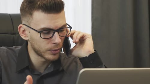 Angry businessman talking on phone, close up
