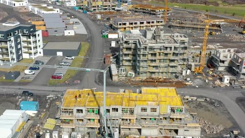 Tower Cranes Erected At Construction Sites In A Developing Area. aerial tilt-up