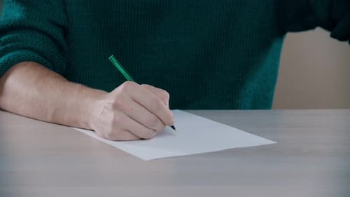 A Man Is Knocking on the Table with a Pen