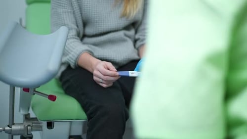 Young Woman Holds Pregnancy Test in Clinic