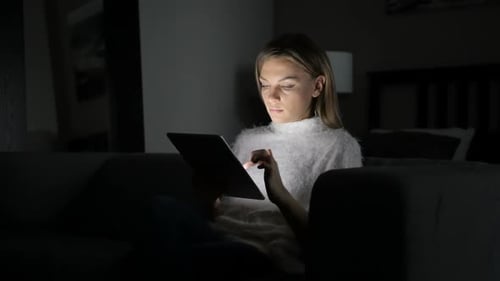Woman Using Tablet Computer at Night