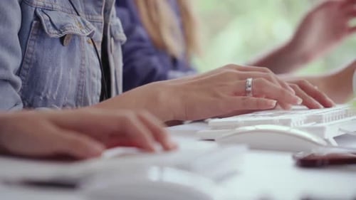 Nahaufnahme einer Geschäftsfrau, die auf dem Schreibtisch mit der Hand tippt und am Computer arbeitet